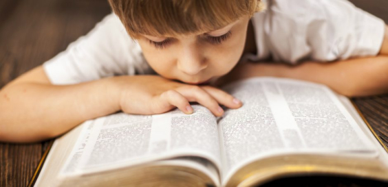 Boy reading the Bible 940x455